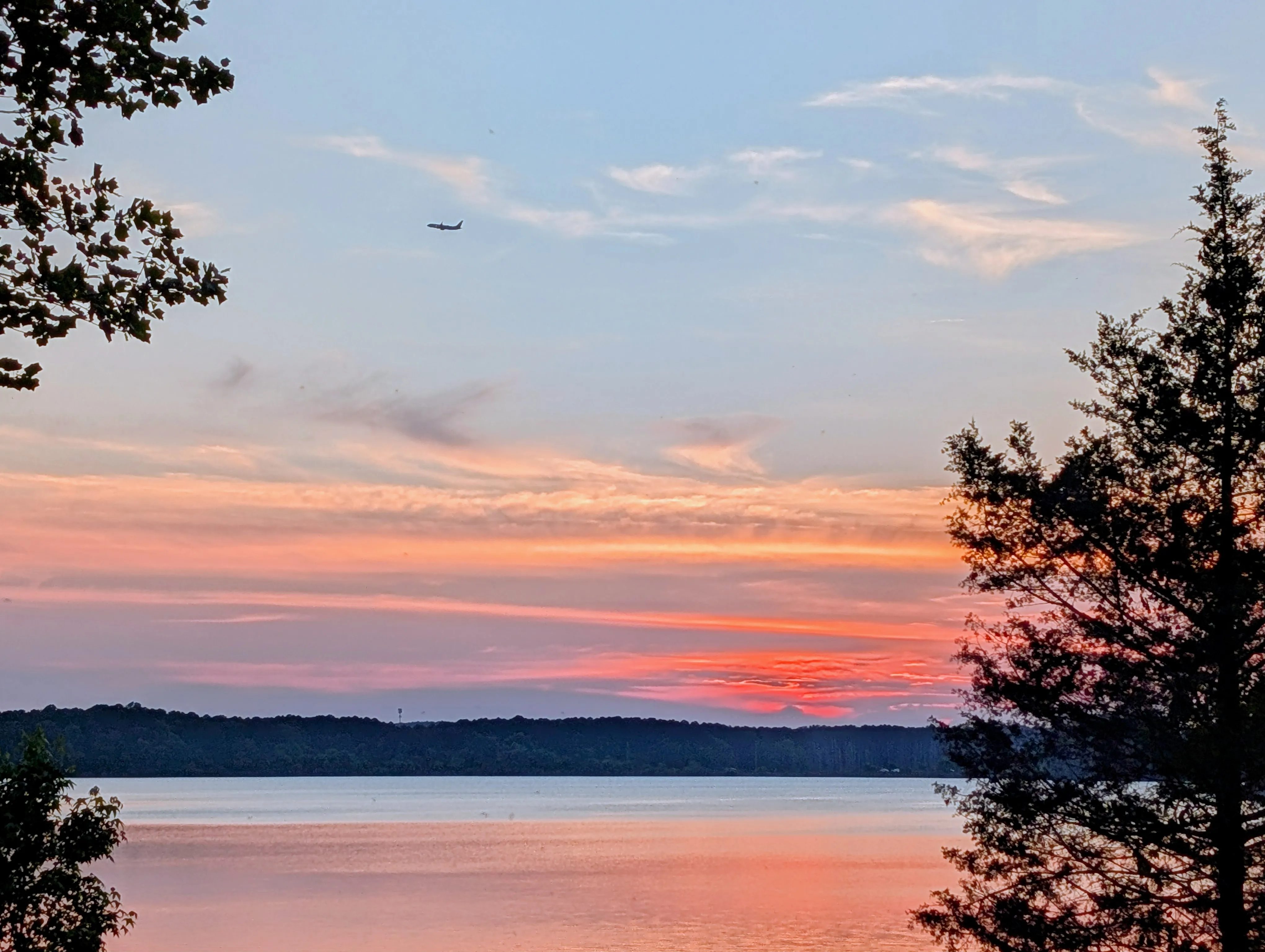 Airplane flying through a sunset